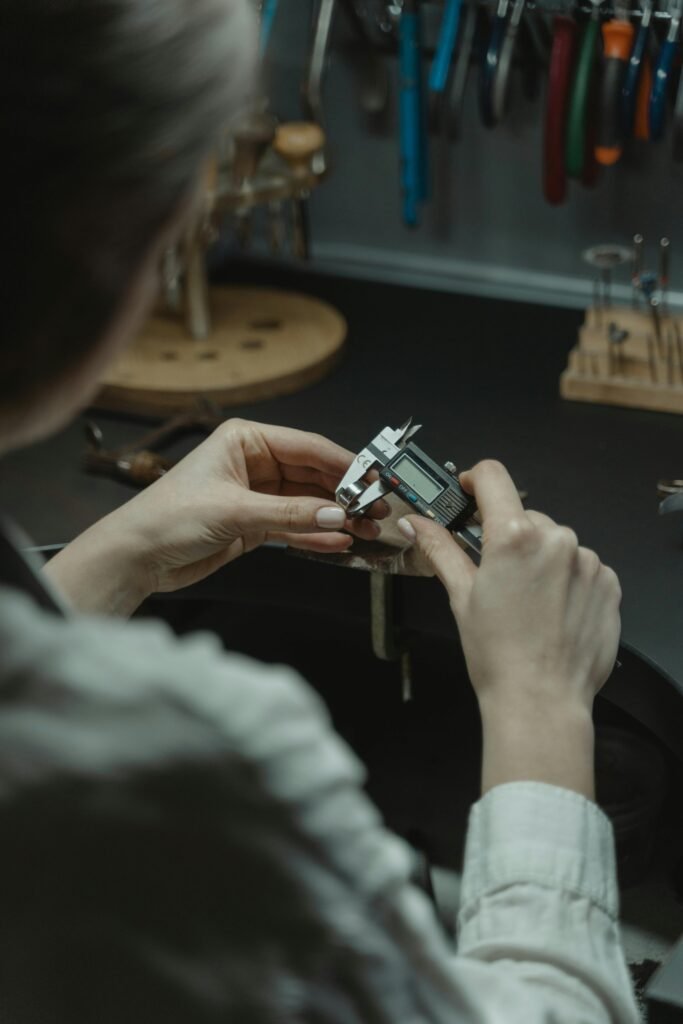 A jeweler uses a caliper to measure with precision in a professional workshop.