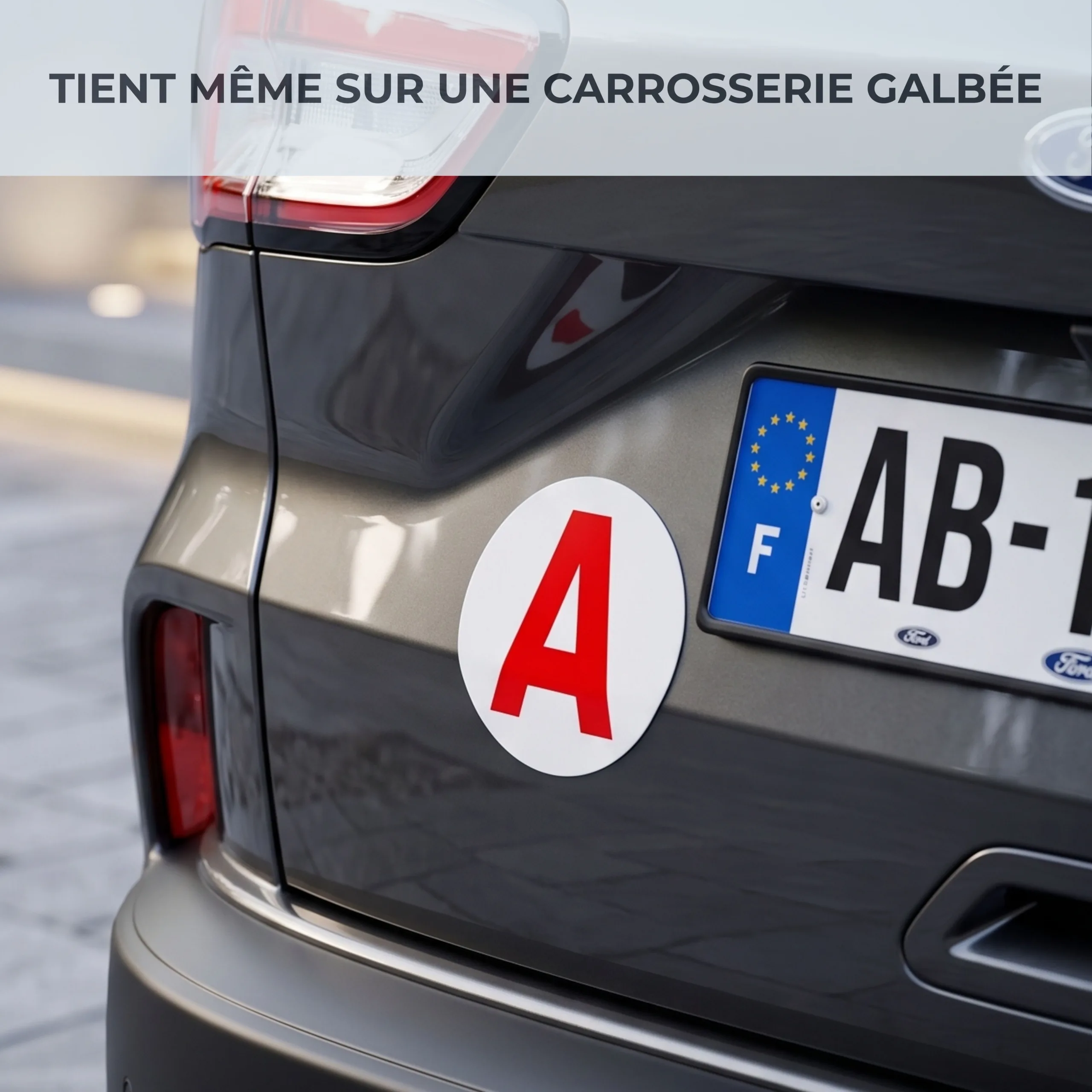 Disque A Habeygard® aimanté sur le hayon galbé d'une voiture grise, à côté de la plaque