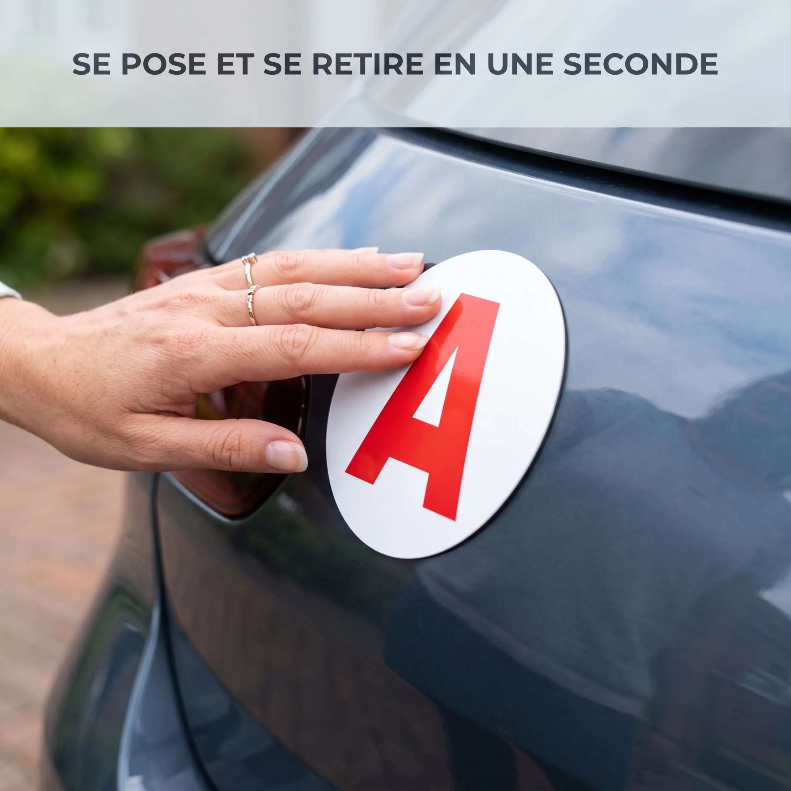 Main posant un disque A magnétique Habeygard® sur la carrosserie d'une voiture bleue